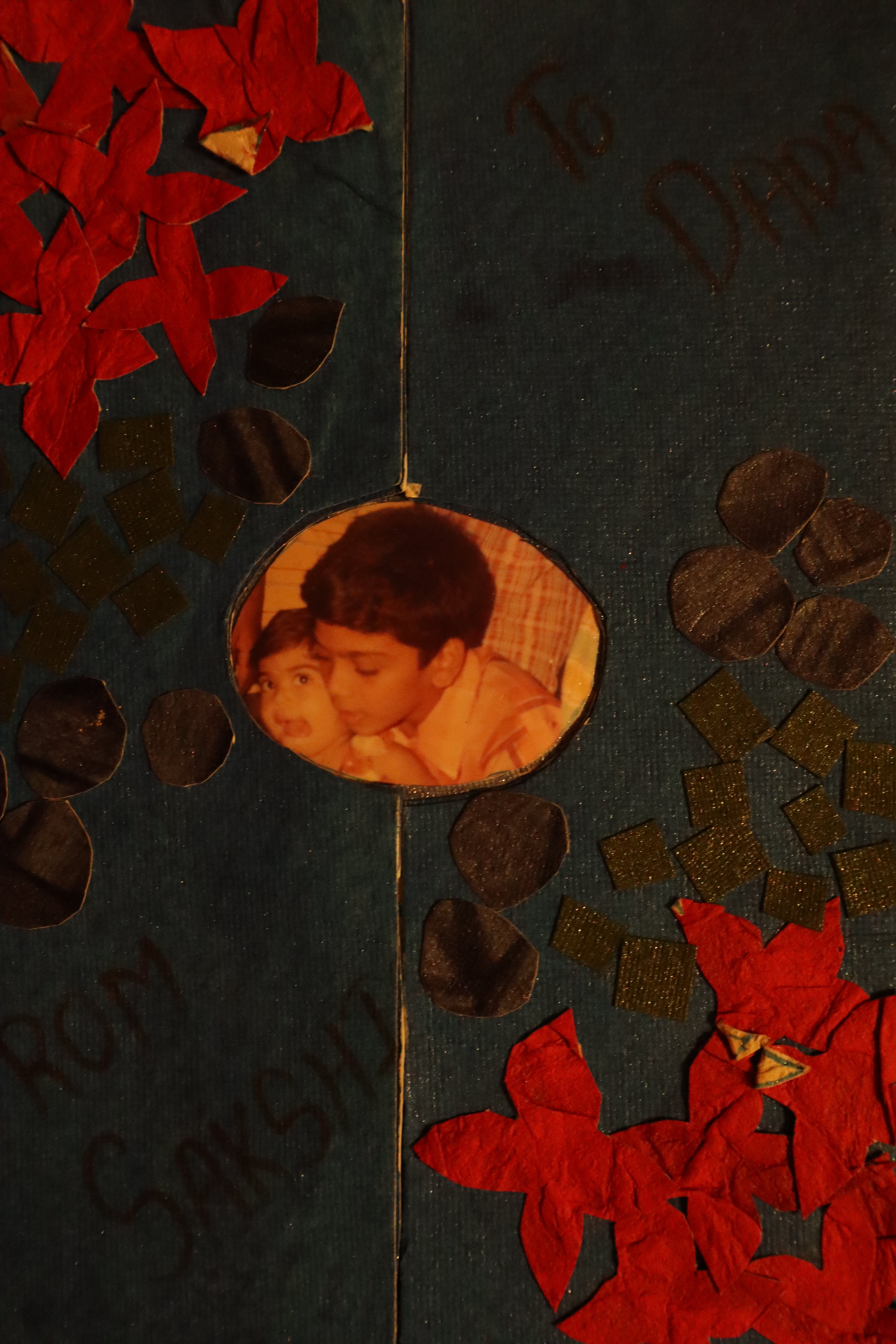 greetin card with red flowers and a photo of two children in the center